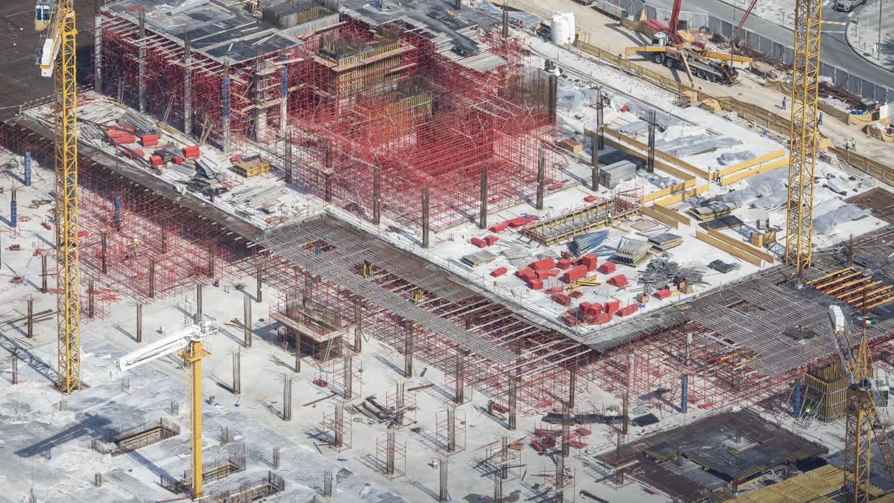 Aerial View of Large Construction Site with Cranes and Scaffolding