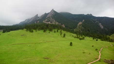 ascenso aéreo sobre la tierra de los gases de la formación rocosa de los flatirones, senderos de senderismo, boulder, colorado