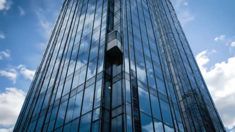 a captivating view of a modern glass building reflecting clouds and blue sky, showcasing innovative architecture and urban design in an urban landscape