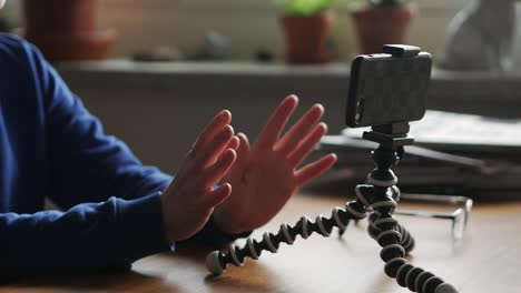 female sitting in front of smartphone on tripod recording video