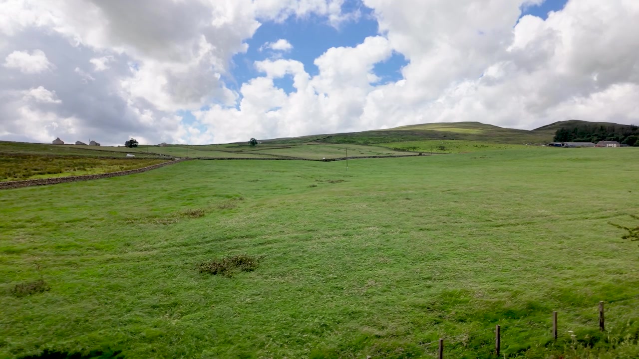 Vista idilliaca delle verdi colline ondulate della campagna inglese in una giornata luminosa e nuvolosa.