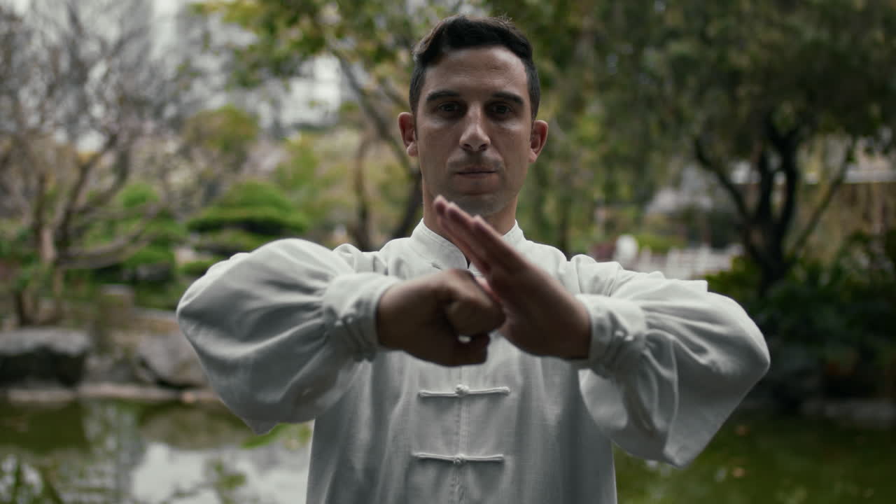 Man practicing martial arts in a tranquil Chinese garden