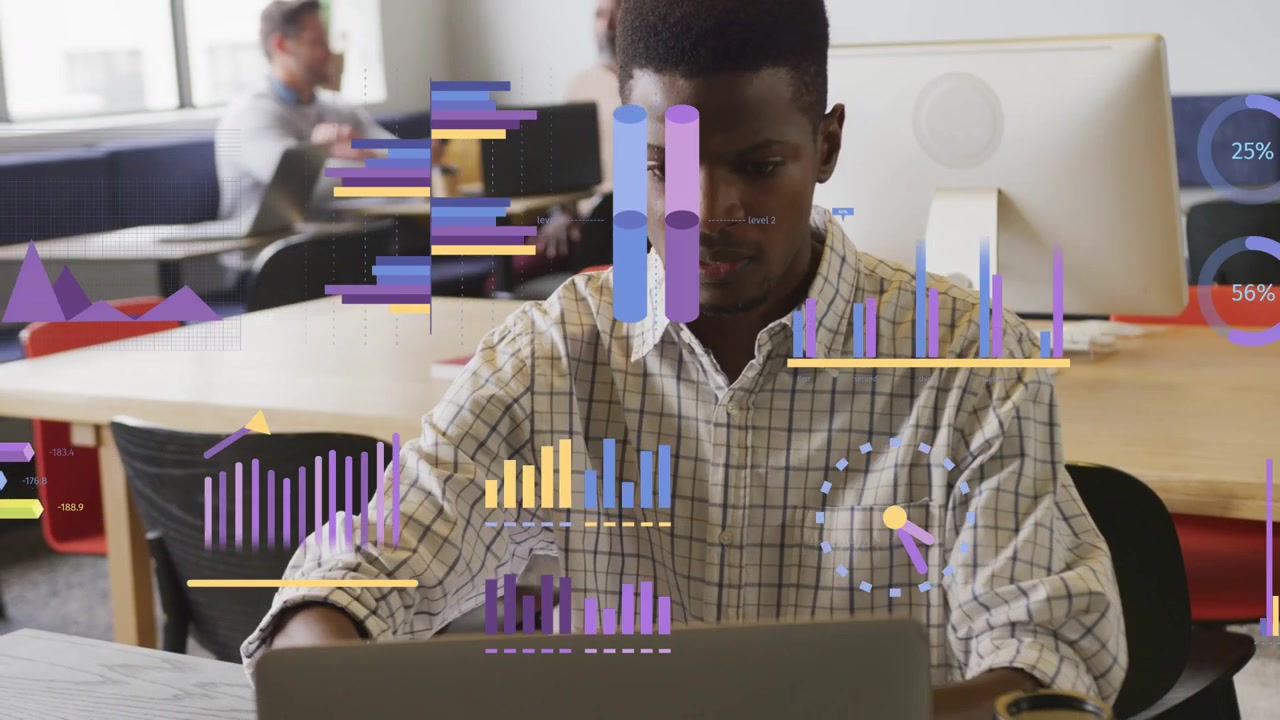 Man writing then typing on laptop, initiating animated charts overlaying for data dashboard review