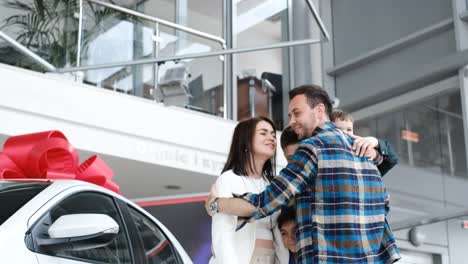 European Family Inspecting a Car at a Dealership Video. European family inspecting a car at a dealership. A young couple in love buys a new car at a car dealership