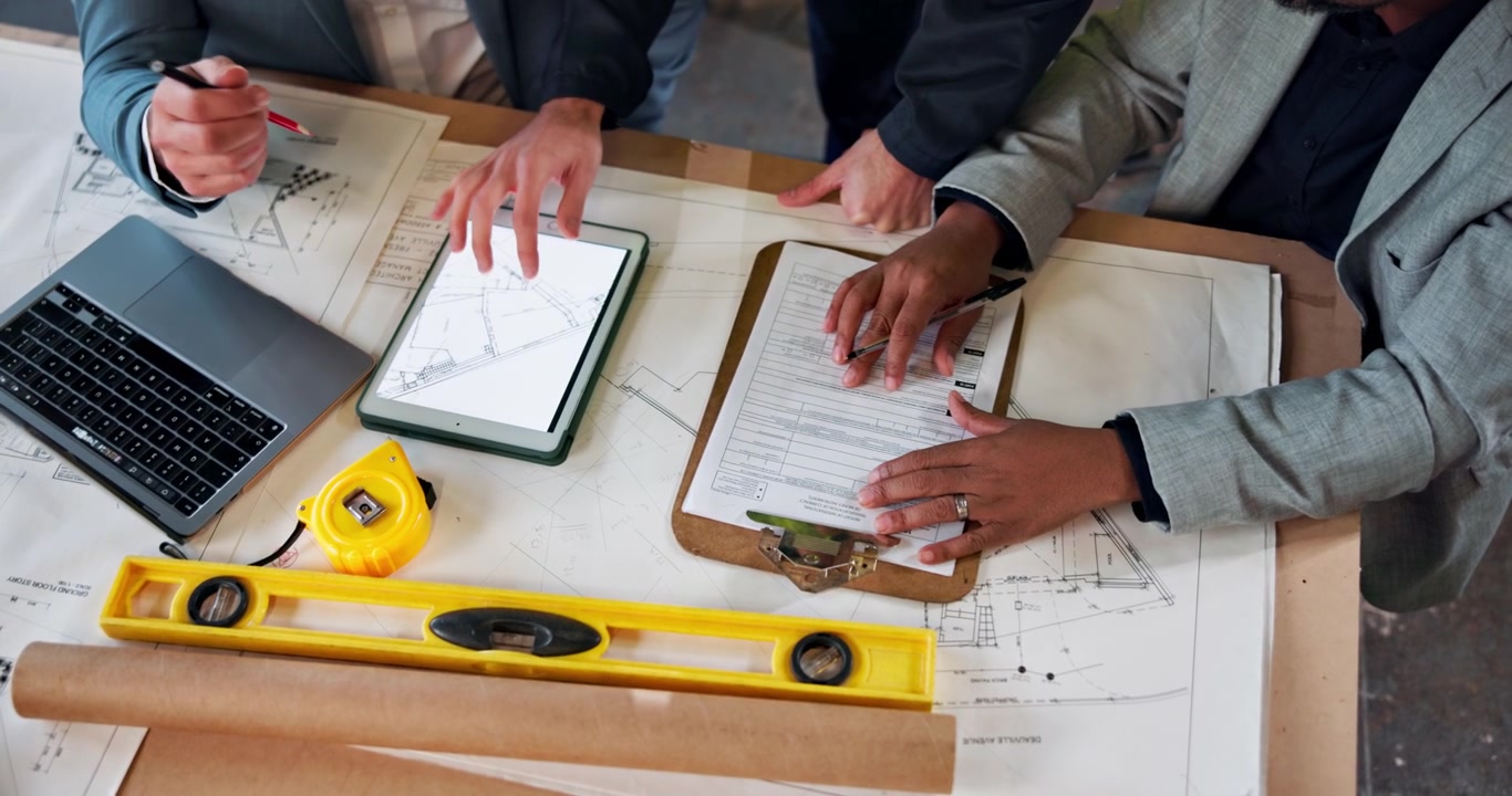 Architects and Engineers Reviewing Construction Blueprints in Office