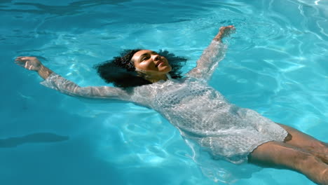 hermosa mujer flotando en el agua de la piscina