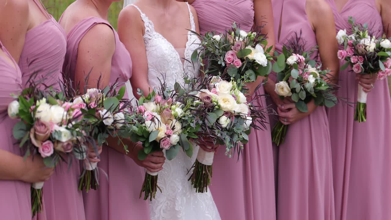 Vakker hvit, rosa og grønn bryllupsbukett med rosa brudepikekjoler