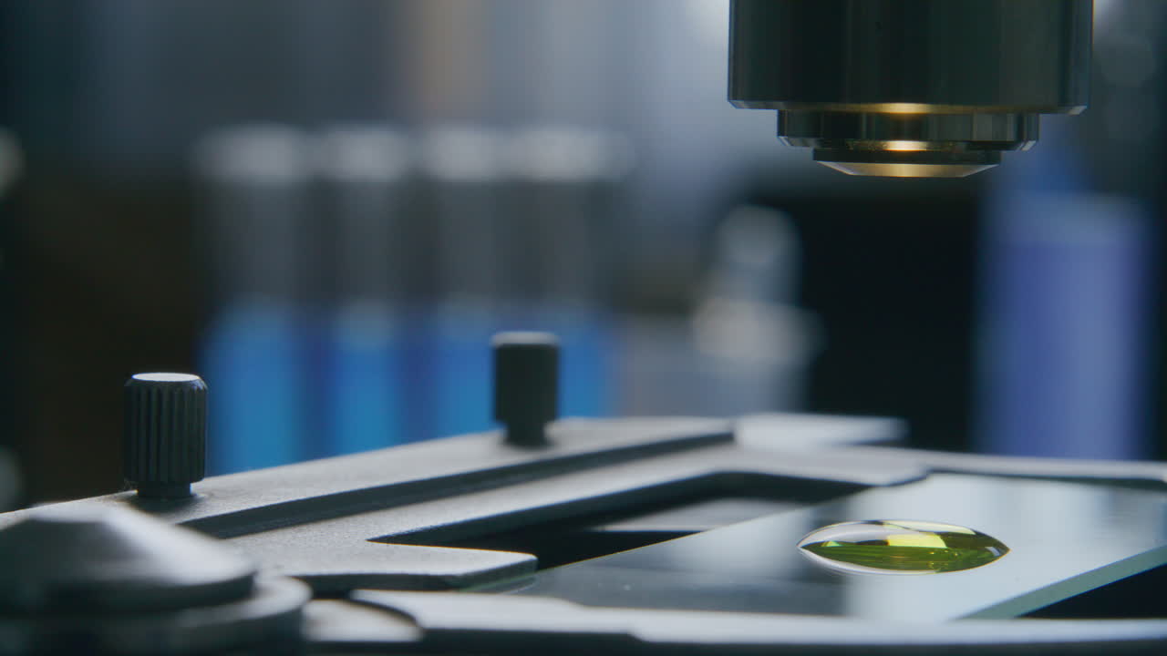 Yellow Liquid Sample on Slide Being Inspected under Microscope