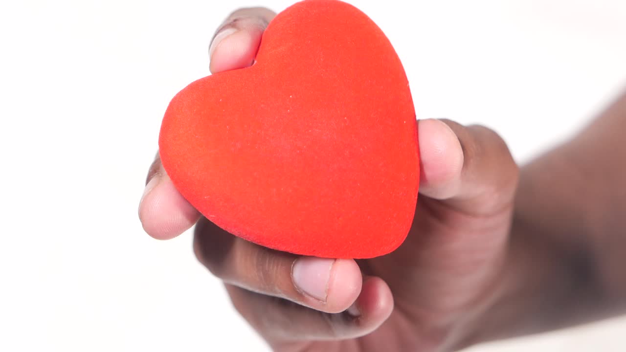 mano sosteniendo un corazón rojo