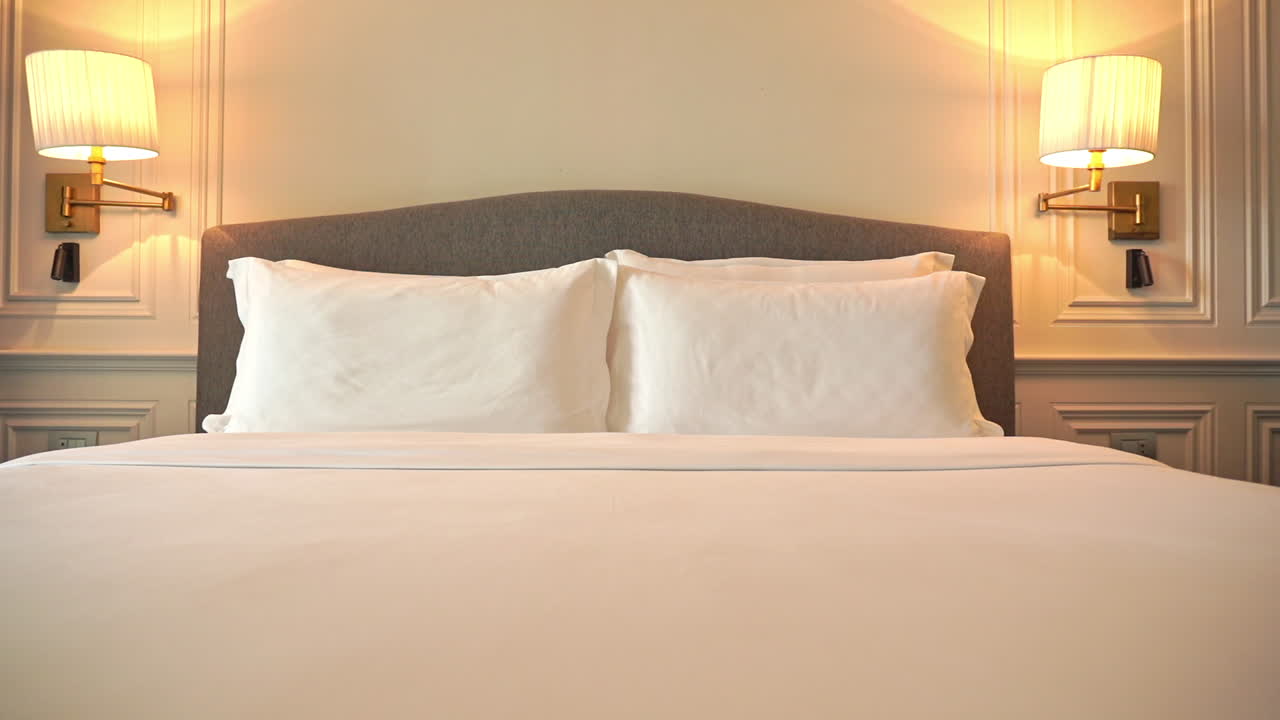 Geseran kamera sepanjang bagian kaki ranjang hotel yang sudah dirapikan