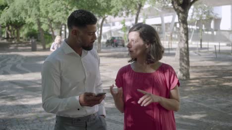 dos personas caminando en el parque de verano y hablando.