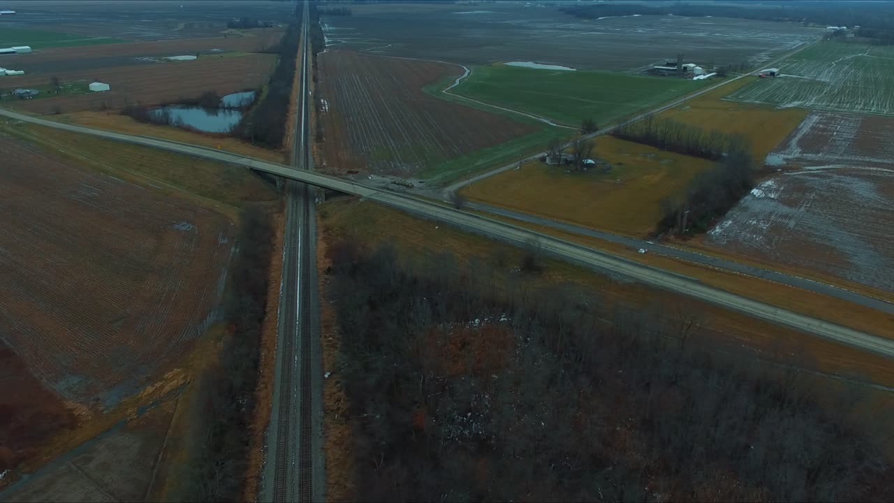시골 일리노이 고속도로의 연못 옆 철로 위를 달리는 고가도로를 가로지르는 자동차, 트럭, 버스