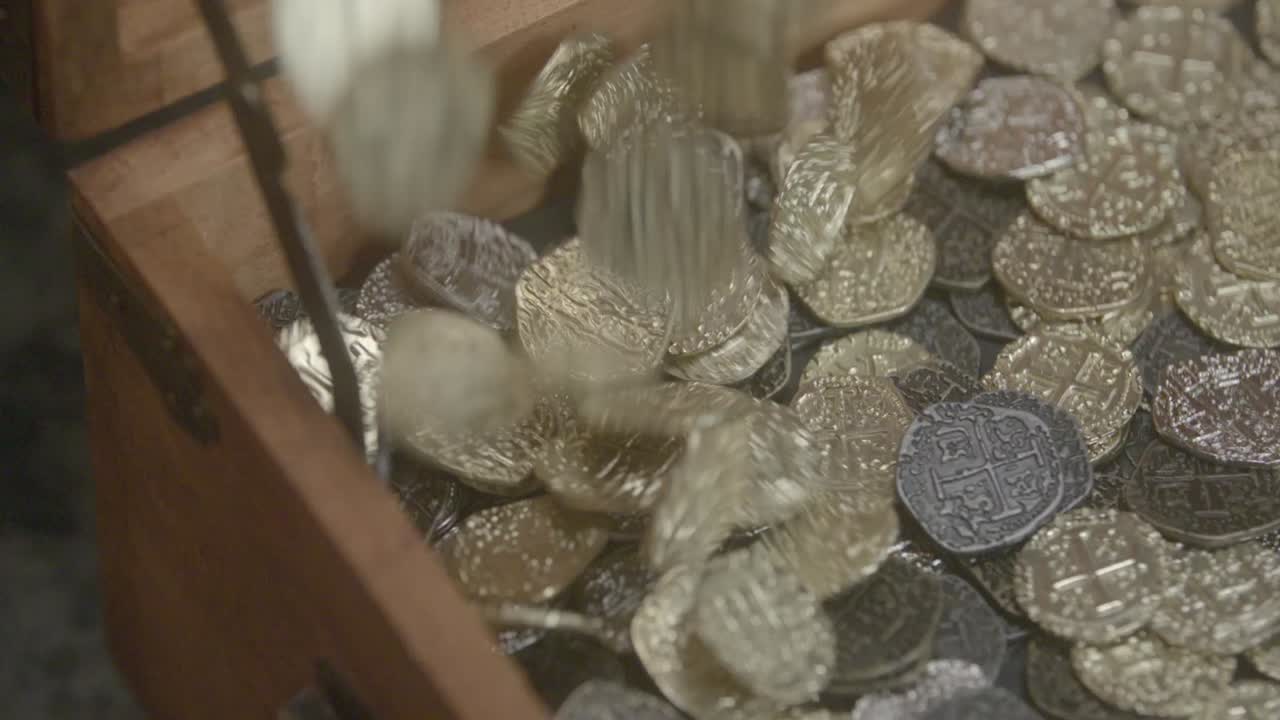 monedas de oro aterrizando en un cofre del tesoro