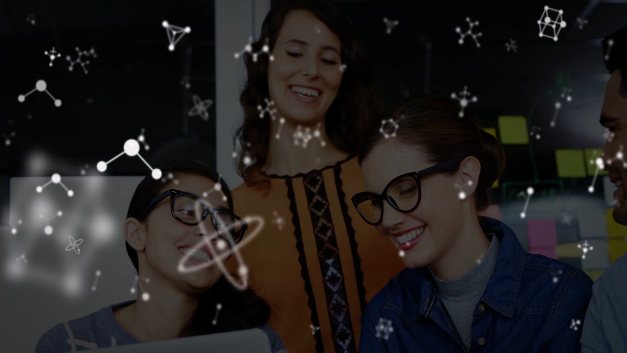 Vertical video: Team leaning into laptop cue, reviewing tech plan with molecules drifting over team
