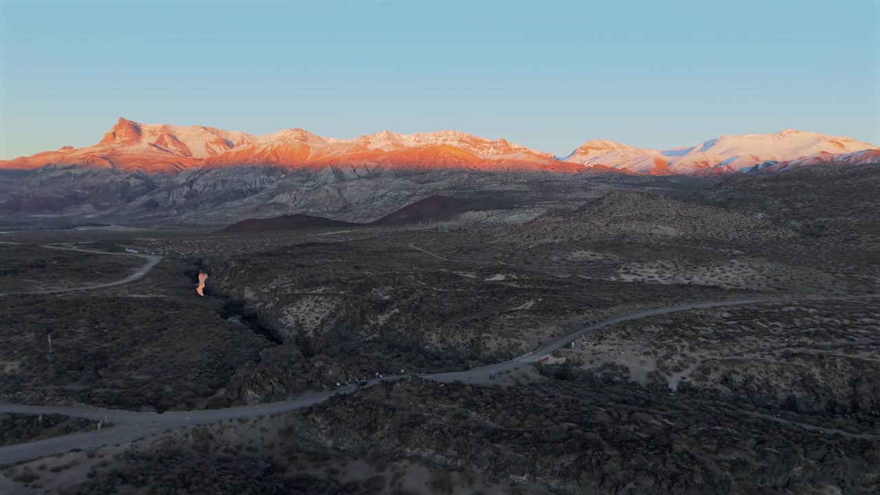 Luce dorata dell'alba che illumina cime frastagliate vicino a un canyon vulcanico. Ripresa aerea lenta con movimento a destra all'alba