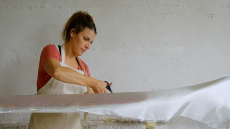 woman cutting fabric for surfboard 4k