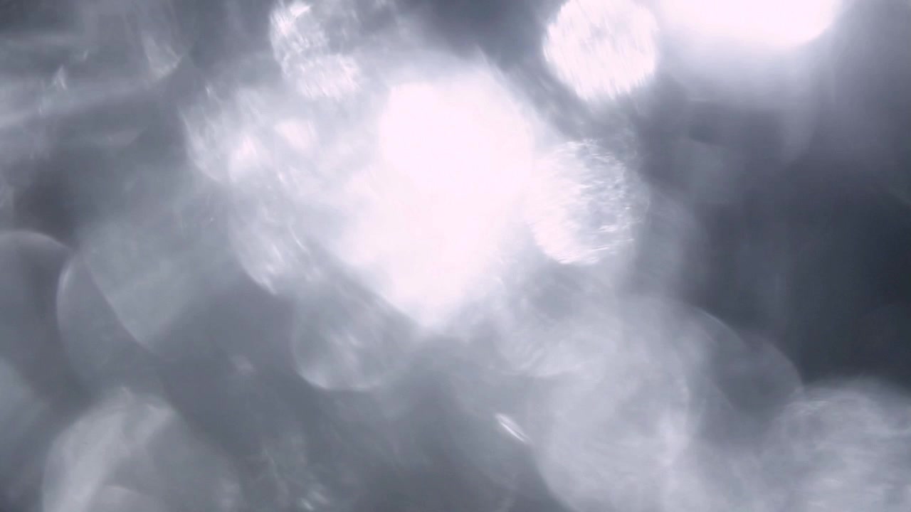 Transizione con perdite di luce bokeh bianche e soffuse su sfondo nero