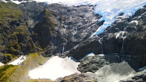 amazing birds eye view of cascade waterfall falling on rocky slope from melting icy glacier