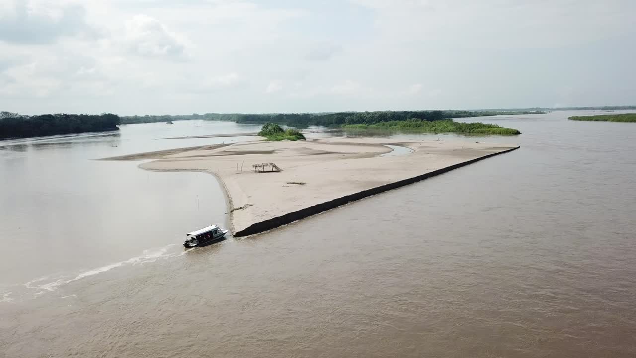 Aerial View of a Boat Approaching a Sandbar Island in a Tropical River