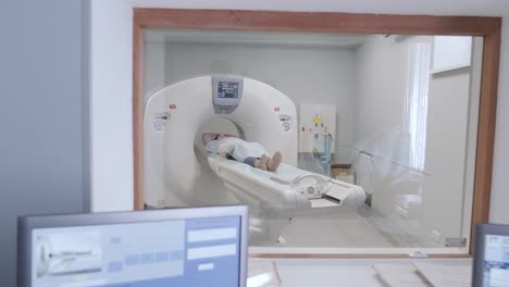 doctor looking at female patient going through ct scan