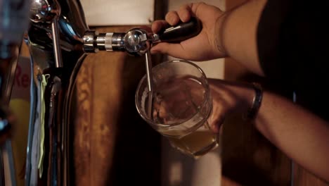 el camarero vertiendo cerveza.
