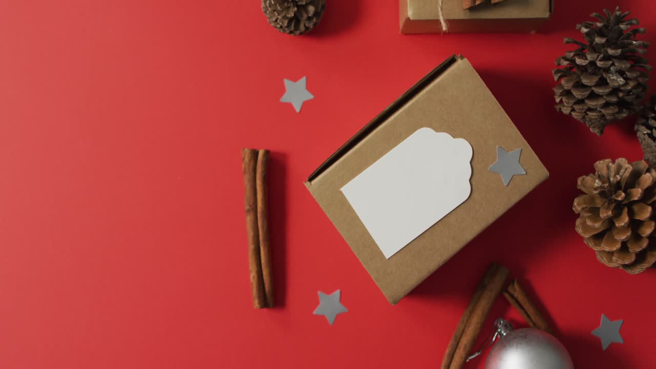 decoraciones de navidad con conos de pino, palitos de canela y espacio de copia sobre fondo rojo