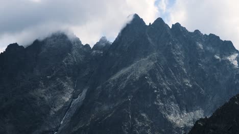 dramatic misty high mountain peaks telephoto closeup by clouds covered in high tatras