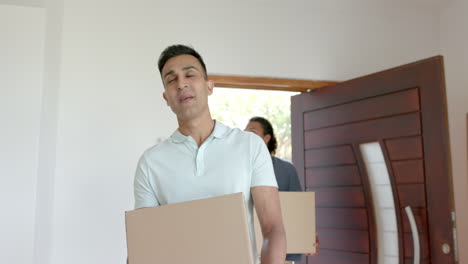 pareja gay feliz y diversa mudándose a una nueva casa, llevando cajas, cámara lenta