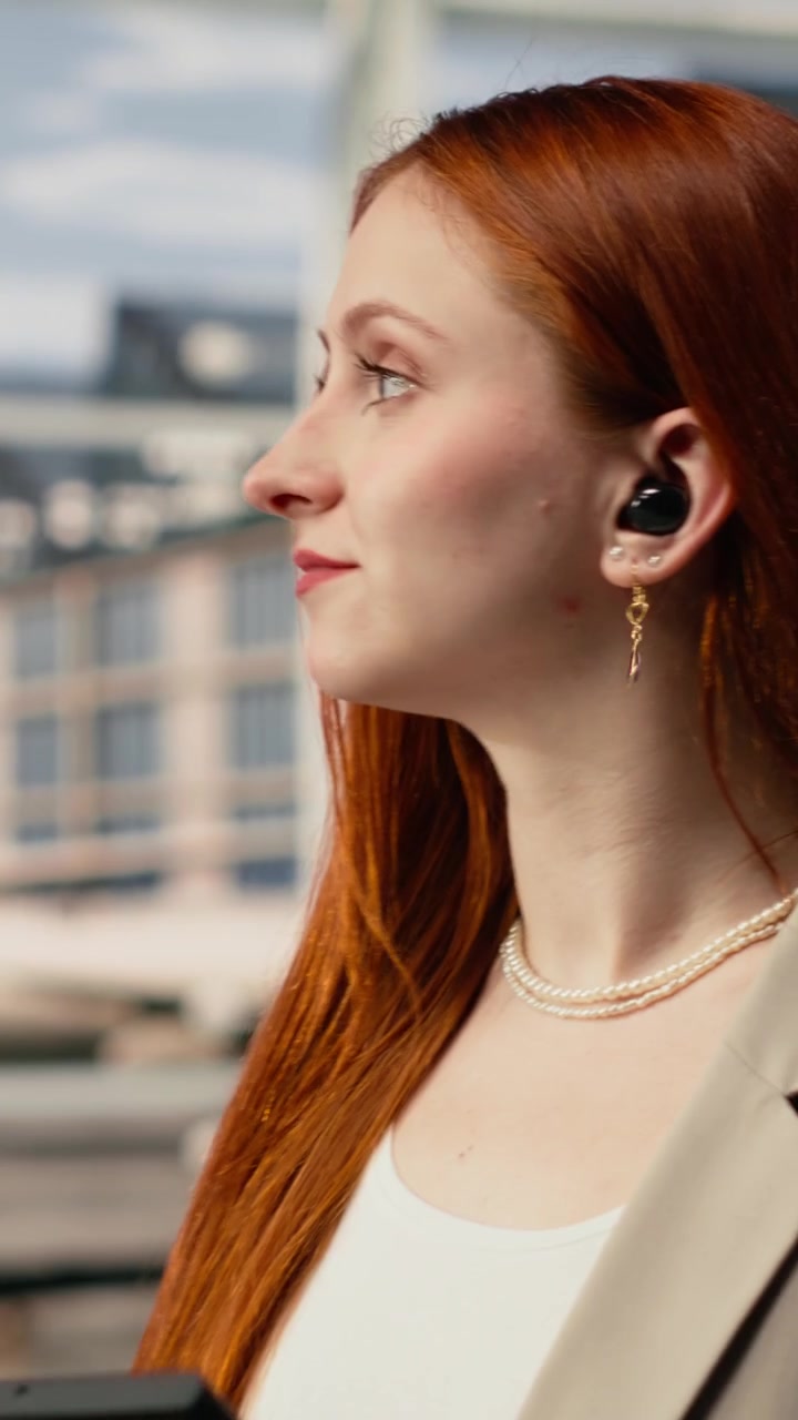 Video verticale. Primo piano di una donna nel terminal dell'aeroporto che usa lo smartphone per chattare con gli amici
