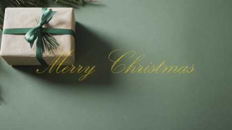 animation of merry christmas text and christmas gift on green background