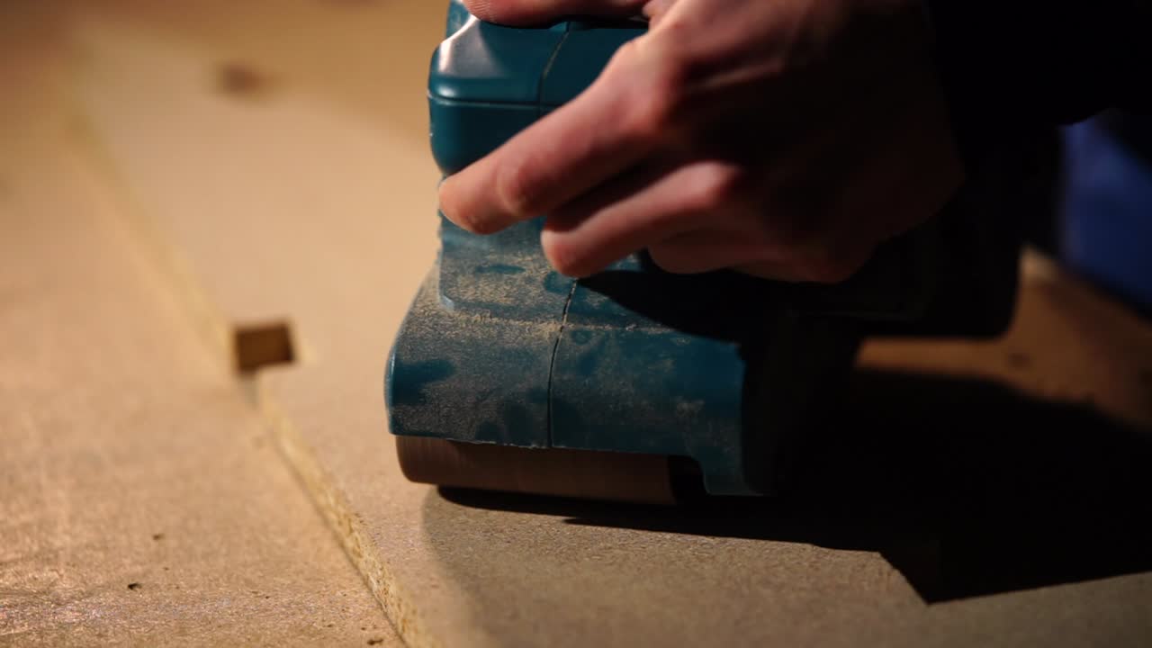 Man Using a Power Sander on Wood