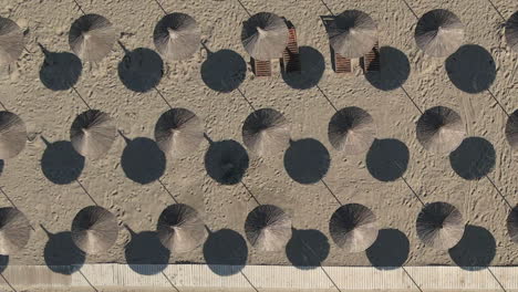 sombrillas de playa de hierba tejida forman un patrón geométrico en la playa soleada