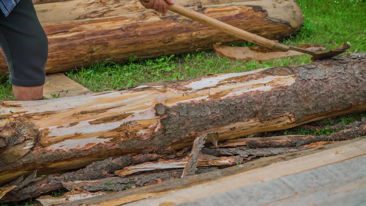 나무 껍질을 벗기기 위해 도구를 사용하는 남자