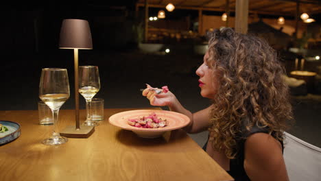 woman slowly eating the gourmet dish at the outdoor summer restaurant