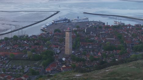 Reveal-shot-of-the-Brandaris-lighthouse-in-West-Terschelling-during-sunrise,-aerial