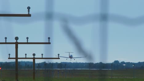 small white training airplane with propeller engines landing at airport in sunny summer day, medium shot from a distance