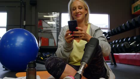 Senior-woman-using-mobile-phone-in-fitness-studio-4k