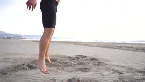 man doing functional exercises training on the beach in slow motion