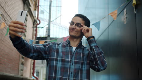 young man taking selfie in urban alley