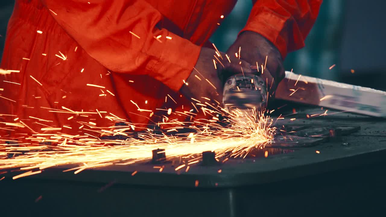 Professional mechanic is cutting steel metal.
