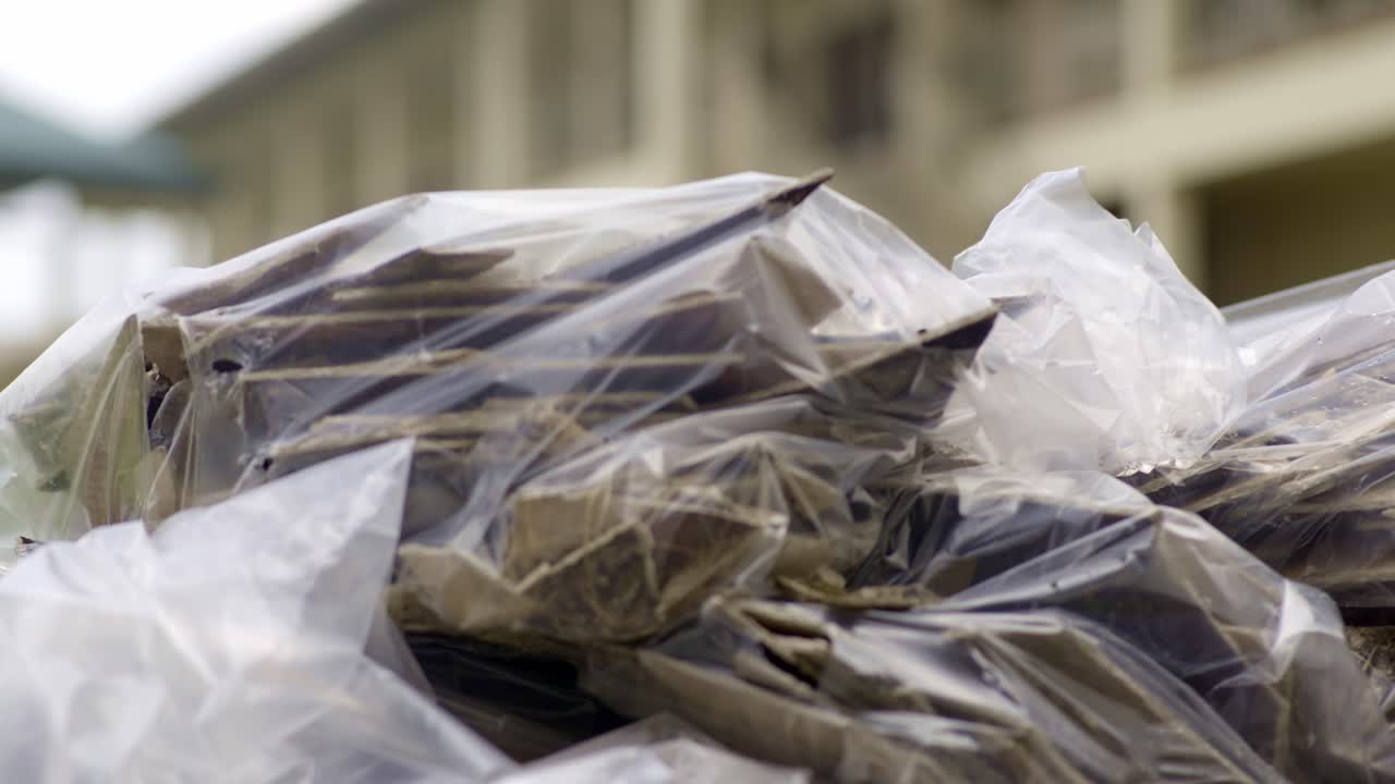 Pieces of asbestos material in plastic bags piled up with sharp edges