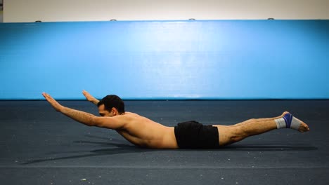 a-guy-doing-a-static-hold-in-a-gymnastics-gym-working-out-his-abs-and-core-muscles-still-shot