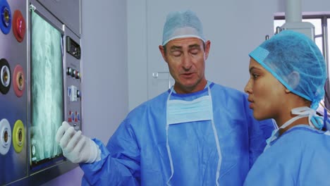 close-up of multi-ethnic doctors discussing over x-ray report on light box in hospital