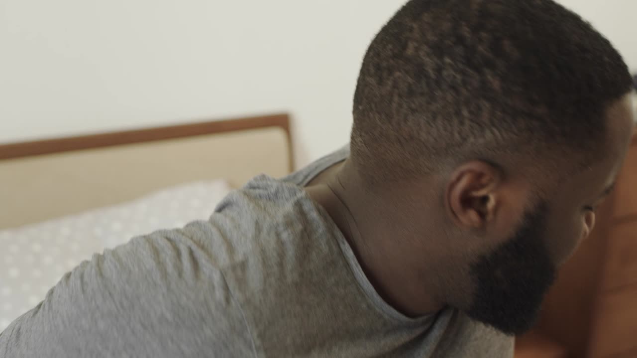 Black man with headache in the morning. Young male person rubbing temple.
