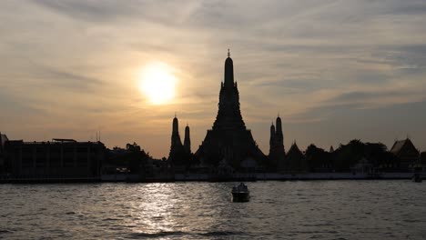 time-lapse of sunset behind a temple by the river