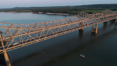 Aerial-shot-of-Bi-State-Vietnam-Gold-Star-Bridge-with-Kentucky-in-background-and-boat-passing-under-bridge