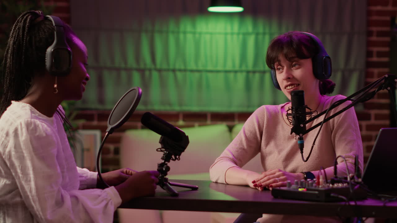 Online podcast host recording interview in front of digital camera for vlog using professional microphone