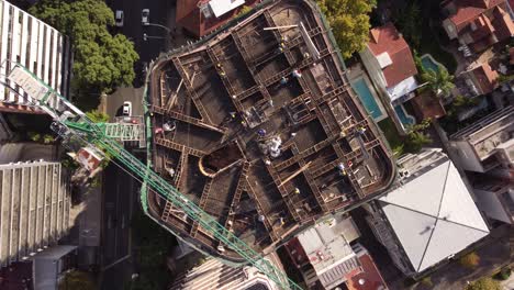 men at work on top of building with crane and industrial equipment for construction site