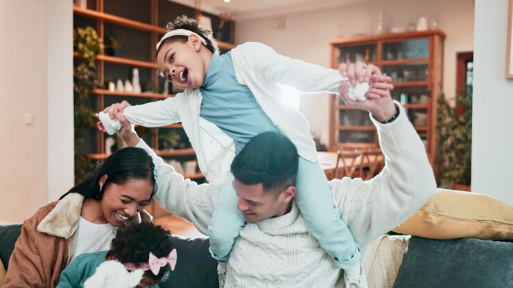 Family, fun and playing on a sofa at home to