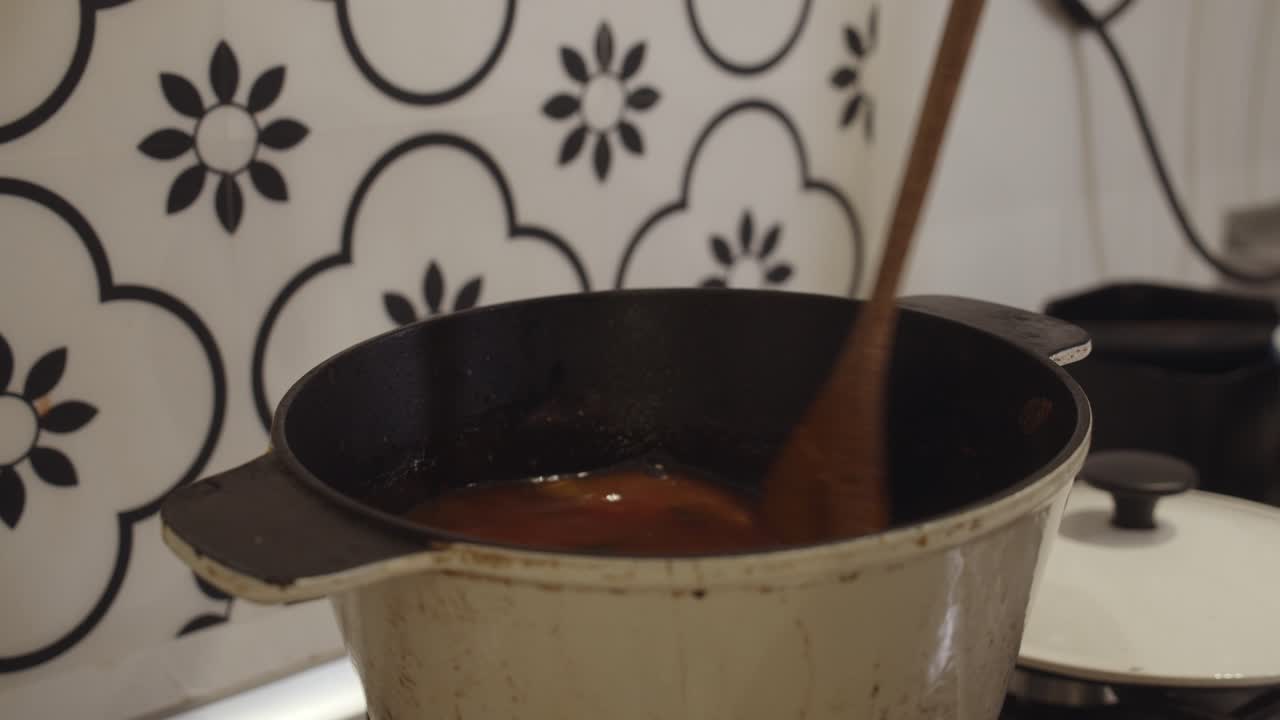 mezclar arroz especiado biriyani en una olla caliente con una cuchara de madera